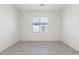 Bright, minimalist bedroom featuring wood-look floors, and a view to the front of the home at 2727 Avril Point St, Las Vegas, NV 89156