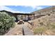 Backyard featuring a covered patio, picnic table, and landscaped pathway creating a serene outdoor experience at 275 Vegas Dr, Goodsprings, NV 89019