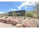 Exterior view of a modern home featuring desert landscaping and a stone walkway, surrounded by natural beauty at 275 Vegas Dr, Goodsprings, NV 89019