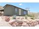 Cozy home nestled in a desert landscape, featuring native vegetation and beautiful rock accents at 275 Vegas Dr, Goodsprings, NV 89019