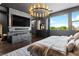 Stylish bedroom featuring a fireplace, TV, contemporary furnishings, and city views from the expansive windows at 298 Grant Ridge Dr, Henderson, NV 89012