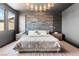 A luxurious main bedroom boasts a stone accent wall, modern lighting, and a plush bed for ultimate comfort at 298 Grant Ridge Dr, Henderson, NV 89012
