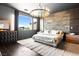 A luxurious main bedroom boasts a stone accent wall, modern lighting, and a plush bed for ultimate comfort at 298 Grant Ridge Dr, Henderson, NV 89012