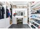 This walk-in closet features custom shelving, an island with a mirror, drawers, and space for shoes and hanging clothes at 298 Grant Ridge Dr, Henderson, NV 89012