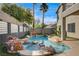 Backyard features a sparkling pool with rock waterfall, palms and lush landscaping at 313 Vista Glen St, Las Vegas, NV 89145