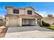 Front exterior featuring a three car garage, desert landscaping, and Spanish-style tile roof at 313 Vista Glen St, Las Vegas, NV 89145