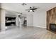 Open living space with wood-look tile flooring, wooden accent wall with fireplace, and adjacent kitchen at 313 Vista Glen St, Las Vegas, NV 89145