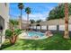 Backyard with a beautiful pool, rock features, a manicured lawn, and lush landscaping at 313 Vista Glen St, Las Vegas, NV 89145