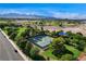 Scenic aerial view of a community tennis court surrounded by trees and greenery, with mountain views in the distance at 313 Vista Glen St, Las Vegas, NV 89145