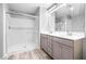 Bathroom with double vanity, framed mirror, walk-in shower, and tile floors at 3188 Via Da Vinci, Henderson, NV 89044