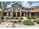 Inviting townhouse featuring a well-manicured lawn and charming facade with stone accents and desert landscaping at 3188 Via Da Vinci, Henderson, NV 89044