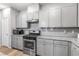 Contemporary kitchen with stone countertops, stainless appliances, and light gray cabinets at 3188 Via Da Vinci, Henderson, NV 89044