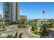 Lush entrance with circular driveway, mature landscaping, and view to the surrounding city at 322 Karen Ave # 308, Las Vegas, NV 89109