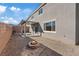 Spacious backyard featuring a covered patio, fire pit, gravel landscaping, and block wall fencing at 340 Autumn Palace Ct, Las Vegas, NV 89144