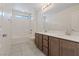 Bathroom features a double sink vanity, a shower-tub combo with white tile, and large mirror at 340 Autumn Palace Ct, Las Vegas, NV 89144