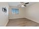 Bright bedroom features modern gray flooring, a ceiling fan, and a window for natural light at 340 Autumn Palace Ct, Las Vegas, NV 89144