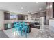 Modern kitchen features stainless steel appliances, gray cabinets, granite counters, and stylish blue bar stools at 340 Autumn Palace Ct, Las Vegas, NV 89144