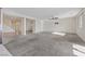 Large carpeted living room featuring a ceiling fan, bright window, and ample space for entertaining or relaxation at 340 Autumn Palace Ct, Las Vegas, NV 89144