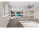 Spacious open-concept living room and kitchen area with carpet, ceiling fan, and ample natural light at 340 Autumn Palace Ct, Las Vegas, NV 89144