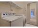 Laundry room with washer, dryer and wire shelving above, next to doorway at 3426 Side Saddle Ct, North Las Vegas, NV 89032