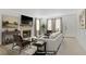 Bright living room featuring a stone fireplace, neutral furniture and natural lighting through draped windows at 3455 Erva St # 112, Las Vegas, NV 89117