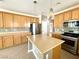 Spacious kitchen featuring stainless steel appliances, a center island, and light wood cabinetry at 3809 Van Ness Ave, North Las Vegas, NV 89081