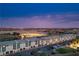 Stunning aerial view of modern townhomes, baseball fields, and the city skyline at dusk at 3880 Enchanted Sky St, Las Vegas, NV 89129