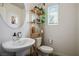 Well-lit powder bathroom featuring a pedestal sink and decorative shelving unit with plants at 3880 Enchanted Sky St, Las Vegas, NV 89129