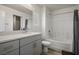 Bright bathroom with gray vanity and solid surface countertop paired with wood-look floors and a shower and tub at 3880 Enchanted Sky St, Las Vegas, NV 89129