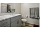Bright bathroom featuring a gray vanity with solid surface countertop, sink, toilet, and wood-look flooring at 3880 Enchanted Sky St, Las Vegas, NV 89129