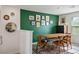 Cozy dining room featuring a wooden table with chairs and a decorative green accent wall with hanging pictures at 3880 Enchanted Sky St, Las Vegas, NV 89129
