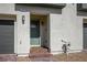 Charming front entrance with a gray door, brick steps, and a convenient two-car garage at 3880 Enchanted Sky St, Las Vegas, NV 89129