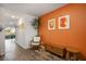 Stylish hallway featuring modern decor, warm wood floors, and an eye-catching orange accent wall at 3880 Enchanted Sky St, Las Vegas, NV 89129