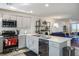 This open-concept kitchen features an island, stainless steel appliances, and access to the living room at 3880 Enchanted Sky St, Las Vegas, NV 89129
