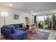 Inviting living room featuring a comfortable blue sofa and a sliding glass door leading to the balcony at 3880 Enchanted Sky St, Las Vegas, NV 89129