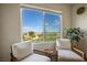 Inviting sitting area featuring two chairs offering landscape views through a bright window with natural light at 3880 Enchanted Sky St, Las Vegas, NV 89129