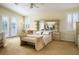 Spacious bedroom featuring a ceiling fan, bright windows, and a bed with matching bench at 404 Via Sonador, Henderson, NV 89012