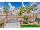 Well-maintained two-story home featuring a tile roof, desert landscaping, palm trees, and a two-car garage at 404 Via Sonador, Henderson, NV 89012