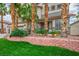 Charming two-story home featuring lush landscaping, mature palm trees, and a brick retaining wall at 404 Via Sonador, Henderson, NV 89012