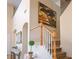 Inviting staircase with oak banister and white balusters, complemented by a large tree art piece at 404 Via Sonador, Henderson, NV 89012