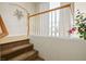 Carpeted staircase features oak railing, white balusters leading to the upper level, and light hardwood floors at 404 Via Sonador, Henderson, NV 89012