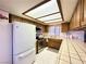 Bright kitchen featuring a white fridge, tile countertops, and wooden cabinets at 4151 Sanderling Cir # 351, Las Vegas, NV 89103