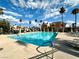 Beautiful community pool with seating, palm trees, and an American flag in the background at 4151 Sanderling Cir # 351, Las Vegas, NV 89103