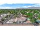 Expansive aerial view of a verdant community, showcasing a single-story home with a backyard pool at 4418 Desert Bloom Ct, Las Vegas, NV 89129