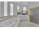 Upscale bathroom featuring a large soaking tub, separate shower, and dual vanity sinks at 4418 Desert Bloom Ct, Las Vegas, NV 89129