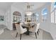Elegant dining room boasting large arched windows, modern chandelier, and dining set at 4418 Desert Bloom Ct, Las Vegas, NV 89129