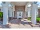 Close up of the front door with glass detailing, brick facade, pillars, and arched windows at 4418 Desert Bloom Ct, Las Vegas, NV 89129