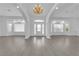 Spacious living room featuring gray flooring, white walls, columns, chandelier, and natural light at 4418 Desert Bloom Ct, Las Vegas, NV 89129