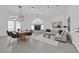 Staged living room and dining area with fireplace, table set and modern decor with lots of natural light at 4418 Desert Bloom Ct, Las Vegas, NV 89129