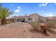 This backyard features desert landscaping, a small patio, and partial shade from large trees at 4628 Standing Bluff Way, Las Vegas, NV 89130